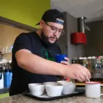ai proof job - person cupping coffee and scoring it with the coffee value assessment